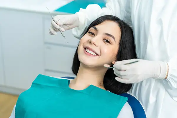 Smiling dental patient sitting in dental chair