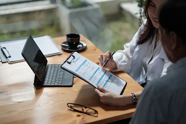 Dentist helping patient fill out insurance paperwork on a clipboard