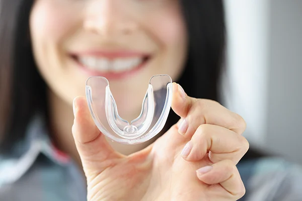 Close up of a simple mouthguard being held up by an excited woman